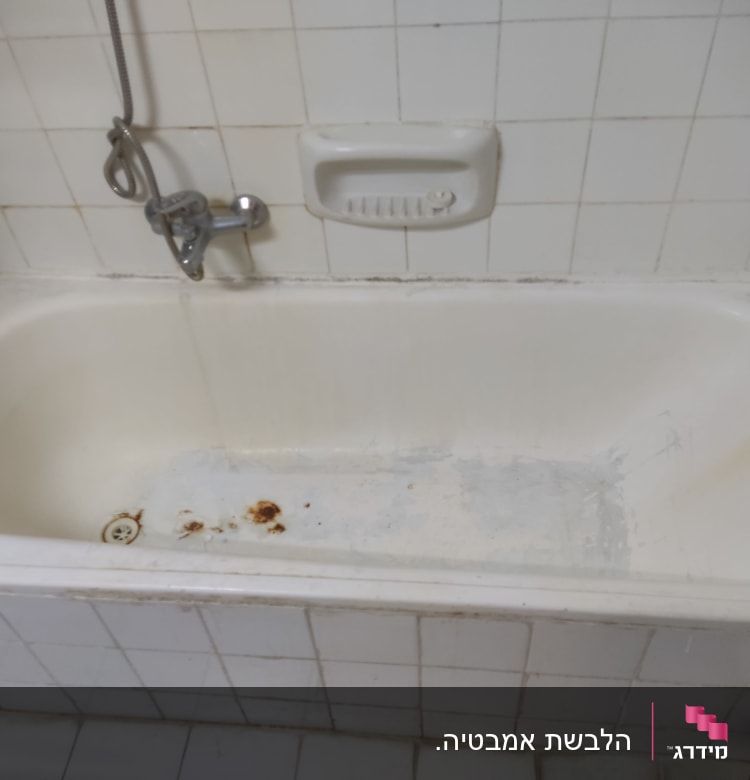 אמבטיה לבנה עם כתמי חלודה וברז מקלחת